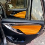 Innova Crysta done customized interior with black and mustard two tone color combination